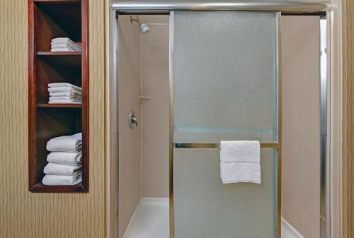 德明戴明汉普顿酒店的浴室里设有玻璃门淋浴