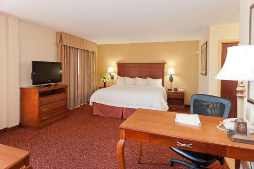 麦库姆麦库姆希尔顿恒庭旅馆&套房酒店的配有一张床和一张书桌的酒店客房