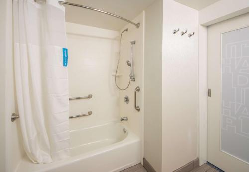 莱克兰莱克兰汉普顿酒店的带淋浴和白色浴缸的浴室