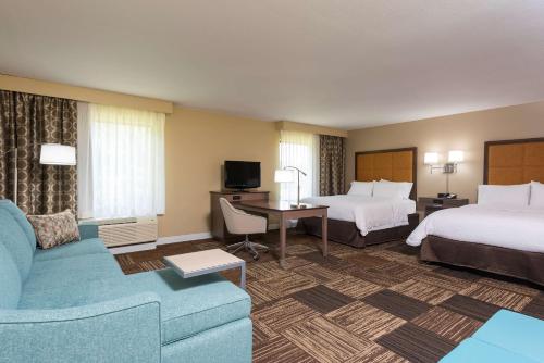 曼斯费尔德南曼斯菲尔德汉普顿酒店及套房@ I 71的酒店客房,设有两张床和一张沙发