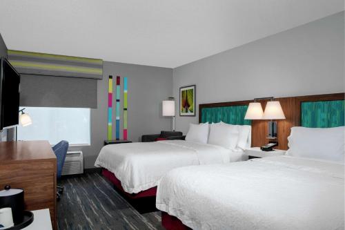奥兰多博伟湖/奥兰多汉普顿酒店的酒店客房设有两张床和一台平面电视。