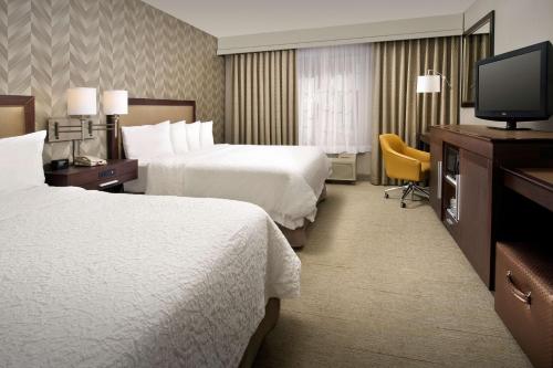 堪萨斯城Hampton Inn Kansas City The Legends的酒店客房设有两张床和一台平面电视。