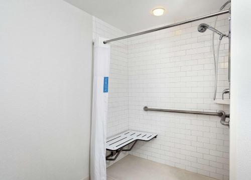 墨尔本墨尔本汉普顿酒店的浴室内铺有白色瓷砖的淋浴和长凳