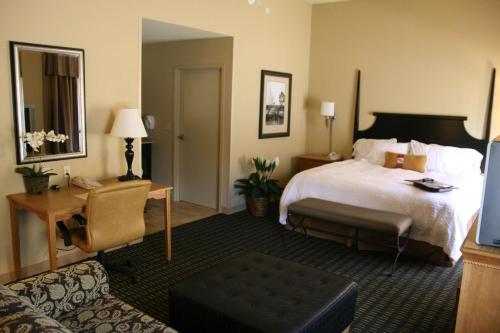 莫比尔摩拜尔普罗维登斯公园/机场希尔顿恒庭旅馆&套房酒店的酒店客房设有一张大床和一张书桌。