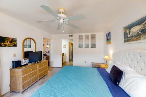 布雷登顿Shorewalk 103的一间卧室配有一张床和吊扇