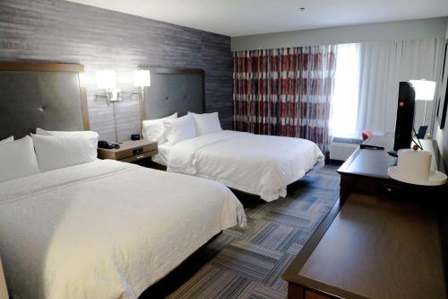 马斯科吉马斯科吉希尔顿恒庭酒店的酒店客房设有两张床和电视。