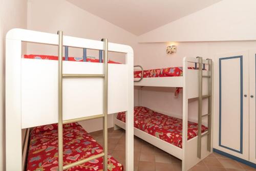 阿尔扎凯纳trilocale con piscina的客房设有2张双层床和红色床单