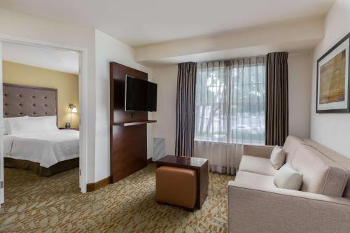 弗里蒙特纽瓦克弗里蒙特希尔顿惠庭套房酒店的酒店客房,配有床和沙发