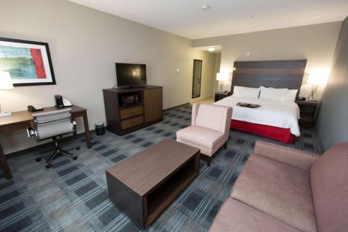 俄克拉何马城俄克拉何马城机场汉普顿酒店及套房的配有一张床和一张书桌的酒店客房