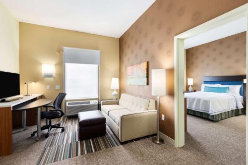 奥马哈奥马哈西部希尔顿惠庭套房酒店的配有一张床和一张书桌的酒店客房
