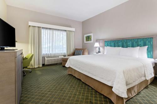 沃思湖沃思湖 - 收费公路 - 西棕榈滩汉普顿酒店的酒店客房设有一张大床和一台电视。