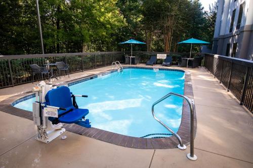 Counce皮克威克达姆汉普顿酒店 - 位于夏伊洛瀑布的大楼前带蓝色椅子的大型游泳池