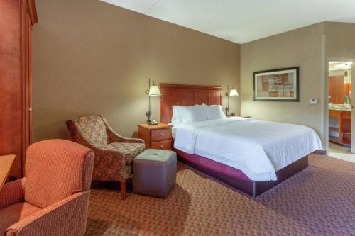 皮奥里亚东皮奥里亚汉普顿酒店的配有一张床和一把椅子的酒店客房