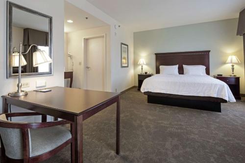 普雷斯科特山谷普雷斯科特谷汉普顿酒店及套房的配有一张床、一张桌子和一张桌子的酒店客房