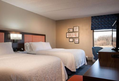 潘思维尔潘尼斯威乐汉普顿旅馆的酒店客房设有两张床和窗户。