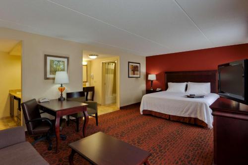 Webster罗彻斯特-韦伯斯特汉普顿酒店的酒店客房设有床和客厅。