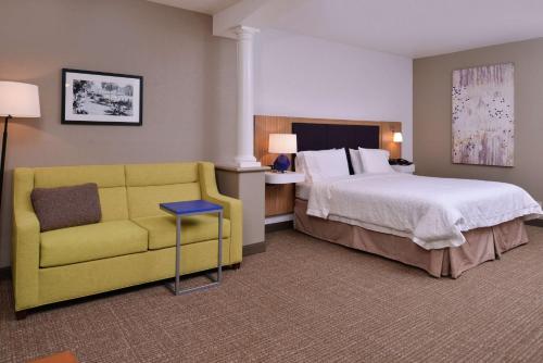 伍德兰林地汉普顿旅馆及套房 - 萨克拉门托地区的酒店客房设有床和黄色沙发