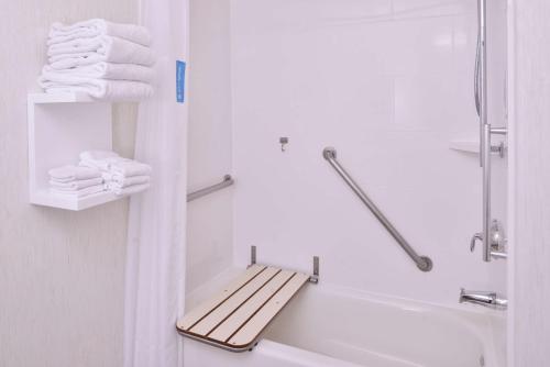 伍德兰林地汉普顿旅馆及套房 - 萨克拉门托地区的浴室配有浴缸旁的毛巾架