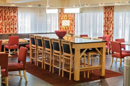 路易斯威尔路易斯维尔机场展/展览中心汉普顿酒店的一间带桌椅的用餐室