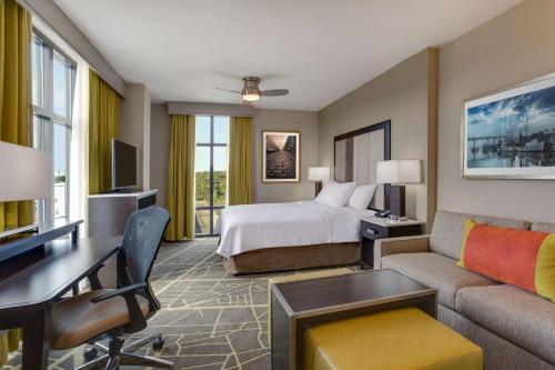 萨凡纳萨凡纳历史区霍姆/滨河伍德套房酒店的配有一张床和一张书桌的酒店客房