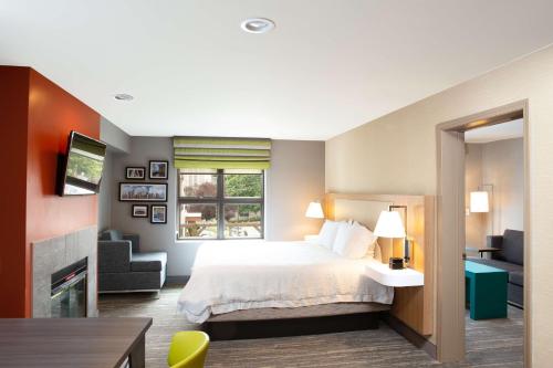 西雅图西雅图市中心汉普顿套房酒店的配有一张床和一把椅子的酒店客房