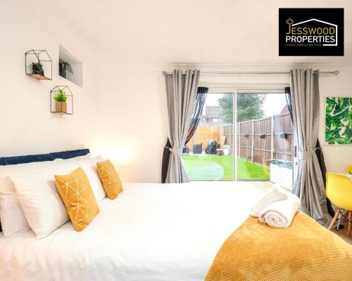 卢顿Bright and Cosy Studio Apartment by Jesswood Properties Short Lets With Free Parking Near M1 & Luton Airport的一间卧室设有一张床和一个大窗户