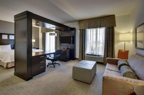 什里夫波特什里夫波特汉普顿酒店的酒店客房配有一张床、一张沙发和一张书桌。
