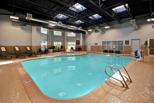 米德瓦尔盐湖城米德维勒/桑迪希尔顿惠庭套房酒店的周围设有大型游泳池,配有椅子