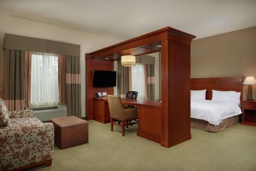 塞勒姆塞勒姆汉普顿套房酒店的酒店客房设有一张天蓬床和一张书桌