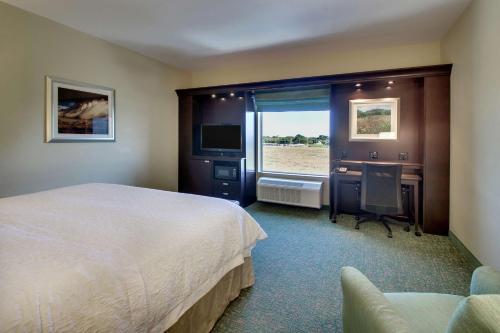 Vernon弗农汉普顿酒店的配有一张床、一张书桌和一扇窗户的酒店客房