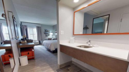 圣西蒙斯岛Hampton Inn St. Simons Island的一间带水槽的浴室和一间带一张床的卧室