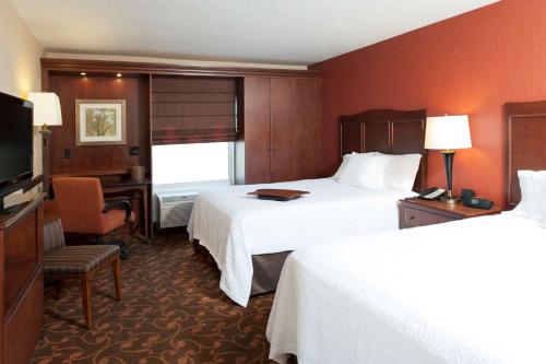 特斯柏罗汉普顿克利夫兰 - 东南 - 崔特斯柏罗旅馆及套房的酒店客房设有两张床、一张桌子和一台电视。