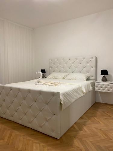 尼克希奇Apartman Oaza的白色卧室配有白色床头板和白色大床