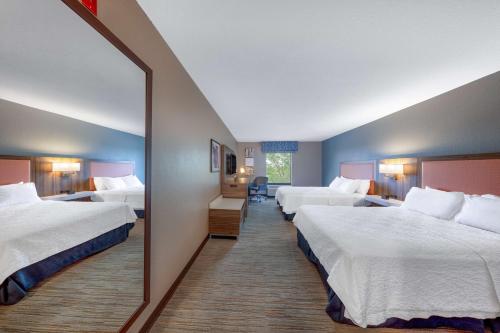 圣罗伯圣罗伯特汉普顿酒店的酒店客房,设有三张床和镜子