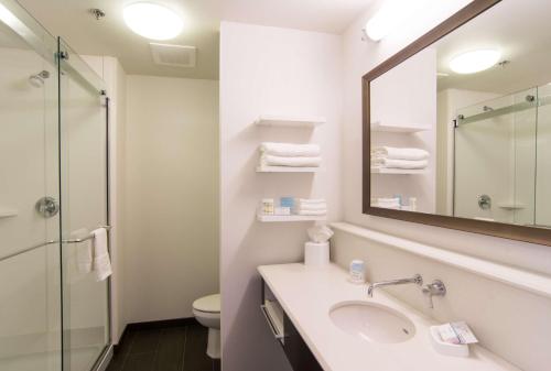 Orange City奥兰治城汉普顿酒店的一间带水槽、镜子和卫生间的浴室