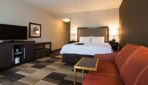 Orange City奥兰治城汉普顿酒店的配有一张床和一台平面电视的酒店客房