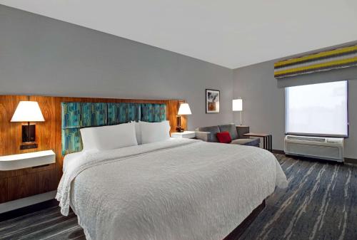 东叙拉古Hampton Inn & Suites by Hilton Syracuse Dewitt的酒店客房设有一张床和一个大窗户