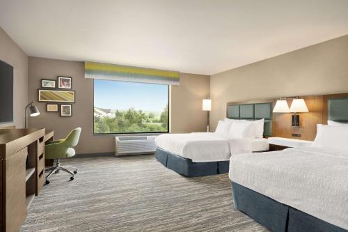 皮阿拉普塔科马/普亚勒普汉普顿套房旅馆的酒店客房设有两张床和窗户。