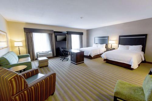 托莱多托莱多/韦斯特盖特汉普顿套房酒店的酒店客房,设有两张床和一张沙发
