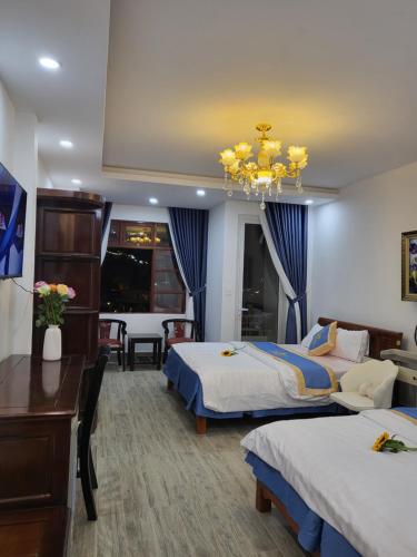 大叻和美酒店的酒店客房设有两张床和吊灯。