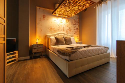萨卢佐Agriturismo Agli ulivi的卧室配有白色的床和吊灯。