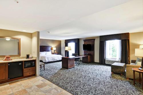 New Hartford新哈特福德/尤蒂卡汉普顿套房酒店的酒店客房设有床和客厅。