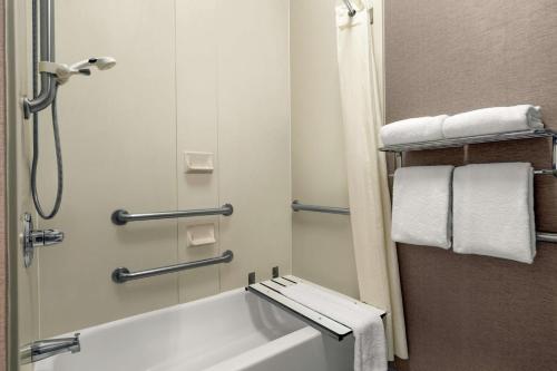 沃里克普罗维登斯-沃里克希尔顿惠庭套房酒店的浴室配有浴缸、淋浴和毛巾。