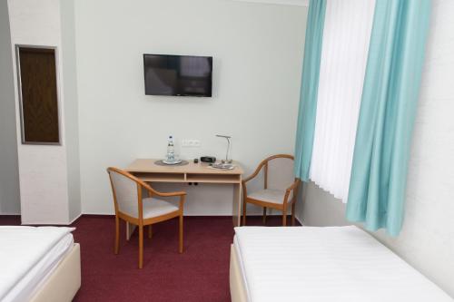 哥达纳赫巴尔德尔克莱恩膳食公寓酒店的配有桌子和两把椅子及一张床的房间
