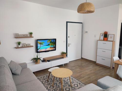 圣金Saeri's Stylish Apartment的客厅配有沙发和墙上的电视