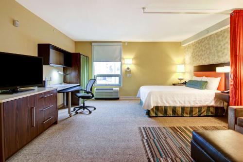 埃德蒙顿西埃德蒙顿希尔顿欣庭套房酒店的配有一张床和一张书桌的酒店客房