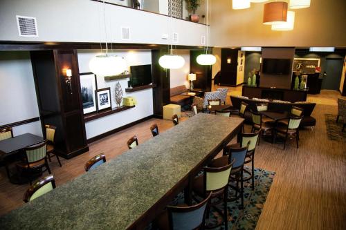 West Middlesex莎朗汉普顿酒店的餐厅内的酒吧,配有桌椅