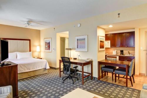 米西索加多伦多密西沙加希尔顿惠庭套房酒店的配有一张床和一张书桌的酒店客房