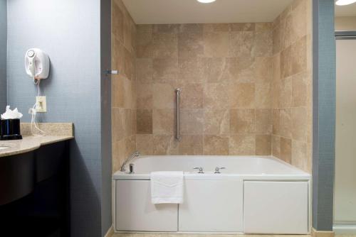 瓦恩兰文兰德希尔顿恒庭旅馆&套房酒店的浴室配有白色浴缸和水槽