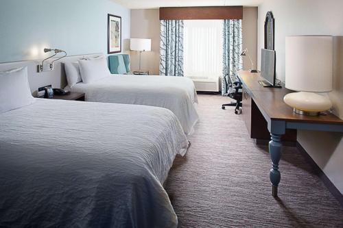 莱瑟姆阿尔巴尼机场希尔顿花园酒店的酒店客房设有两张床和一张书桌及电视